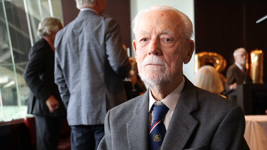 Close-up of WWII veteran Bill Rudd, who is wearing a tie and his war medals.