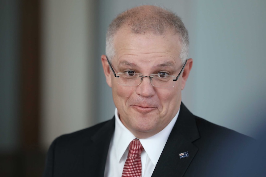 Scott Morrison, with pursed lips and raised eyebrows, wearing glasses and a dark suit.