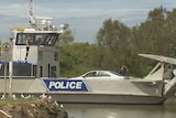 A Qld police barge returns from Macleay Island