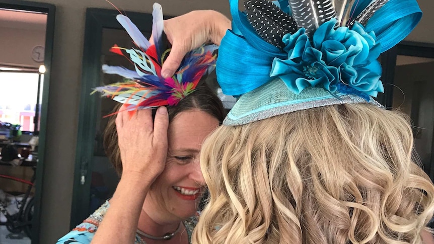 Milliner Felicity Brown fits one of her hats on a friend at XX.