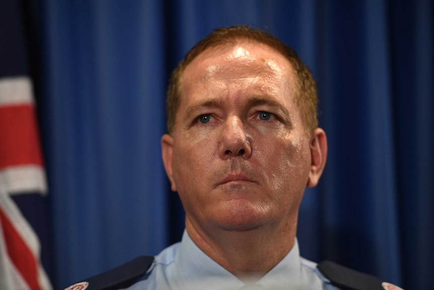 Close up of the Police Commissioner next to an Australian flag.