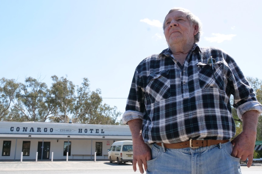 A man looks into the distance, with the Conargo Hotel sign in the background.