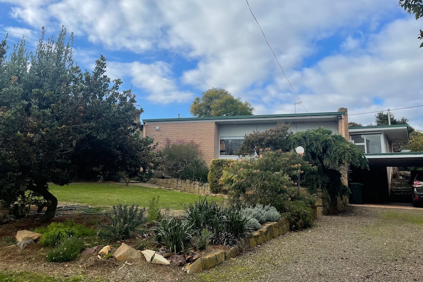 Front angle of brick home with large glass windows  