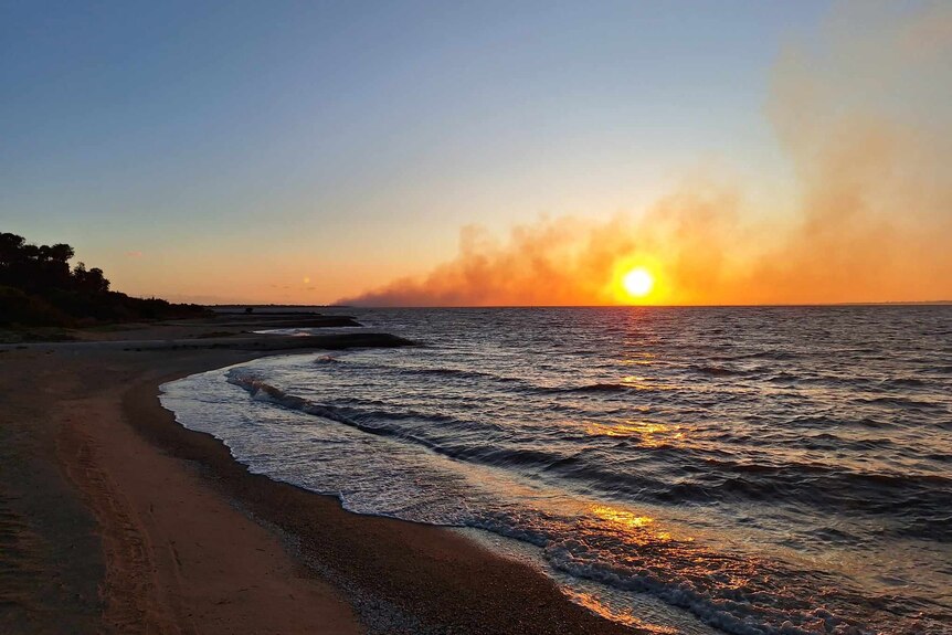 bushfire burns on the horizon across the water
