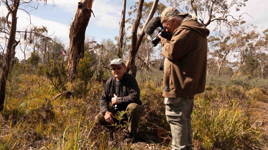 Picture of two men in the bush holding cameras