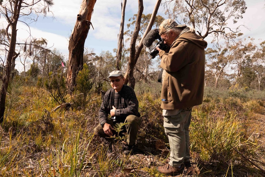 Picture of two men in the bush holding cameras