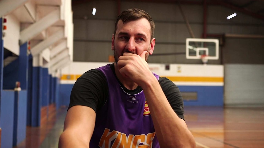 Andrew Bogut sitting with his chin resting in one hand