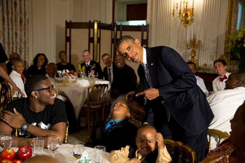 President Barack Obama takes a photo with sleeping boy