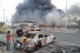 Burnt car in Iraq city of Mosul after attacks