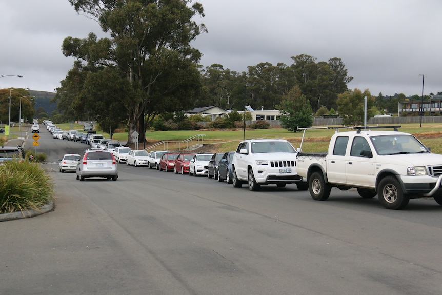 Queues of cars on the side of a road.