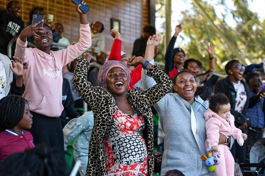 African Australian fans cheer and celebrate in the grandstand