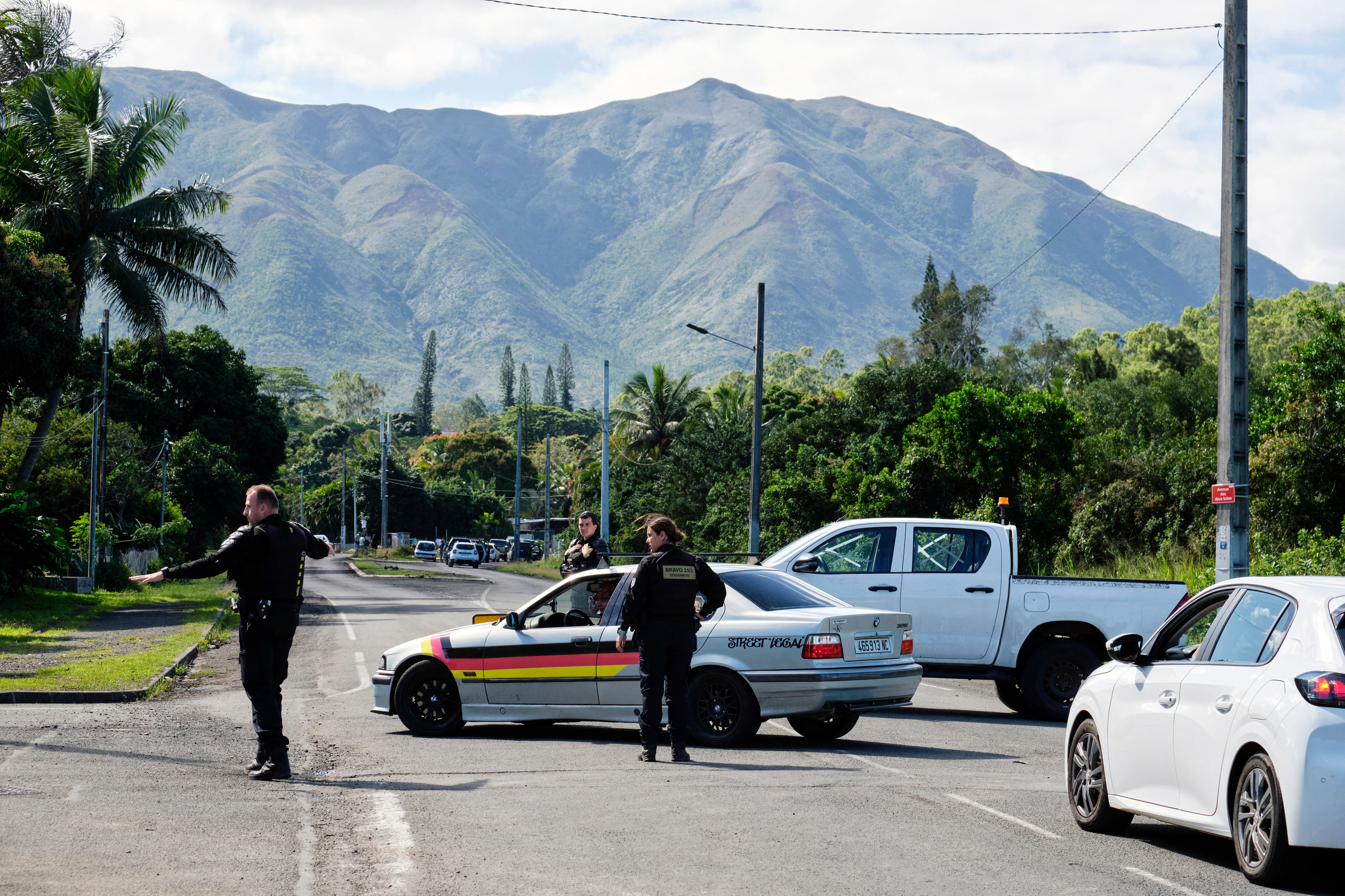 Police blocking a road with their cars direct traffic.