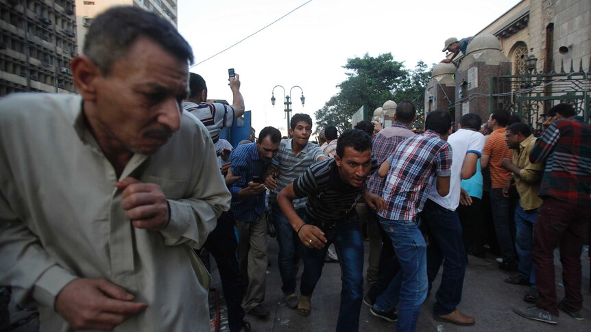 Government supporters run for cover outside Al-Fath mosque