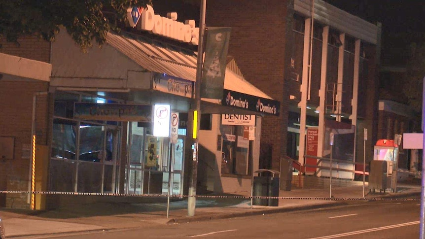 Police tape outside a pizza shop.