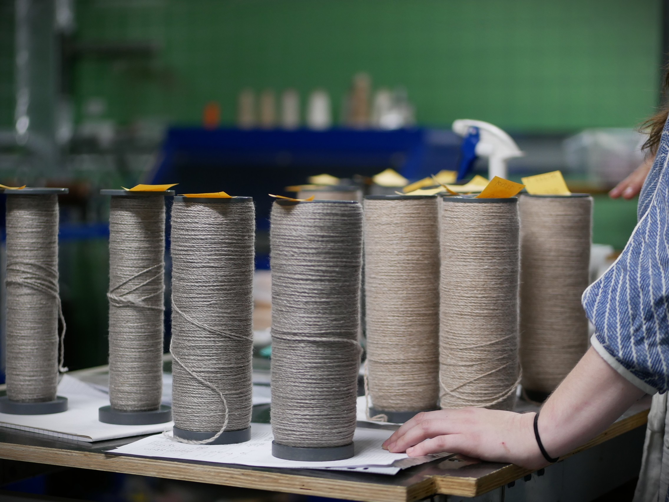 Siete tubos de lana hilada alineados sobre un escritorio