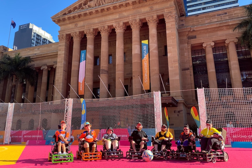 The powerchair footballers line up in front of Brisbane City Hall