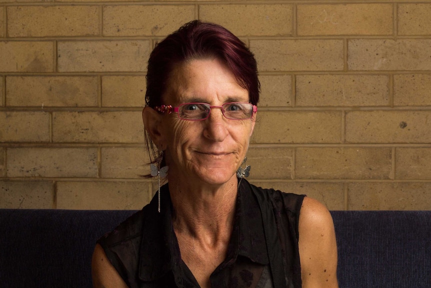 Julie Donoghue sits in front of a wall.