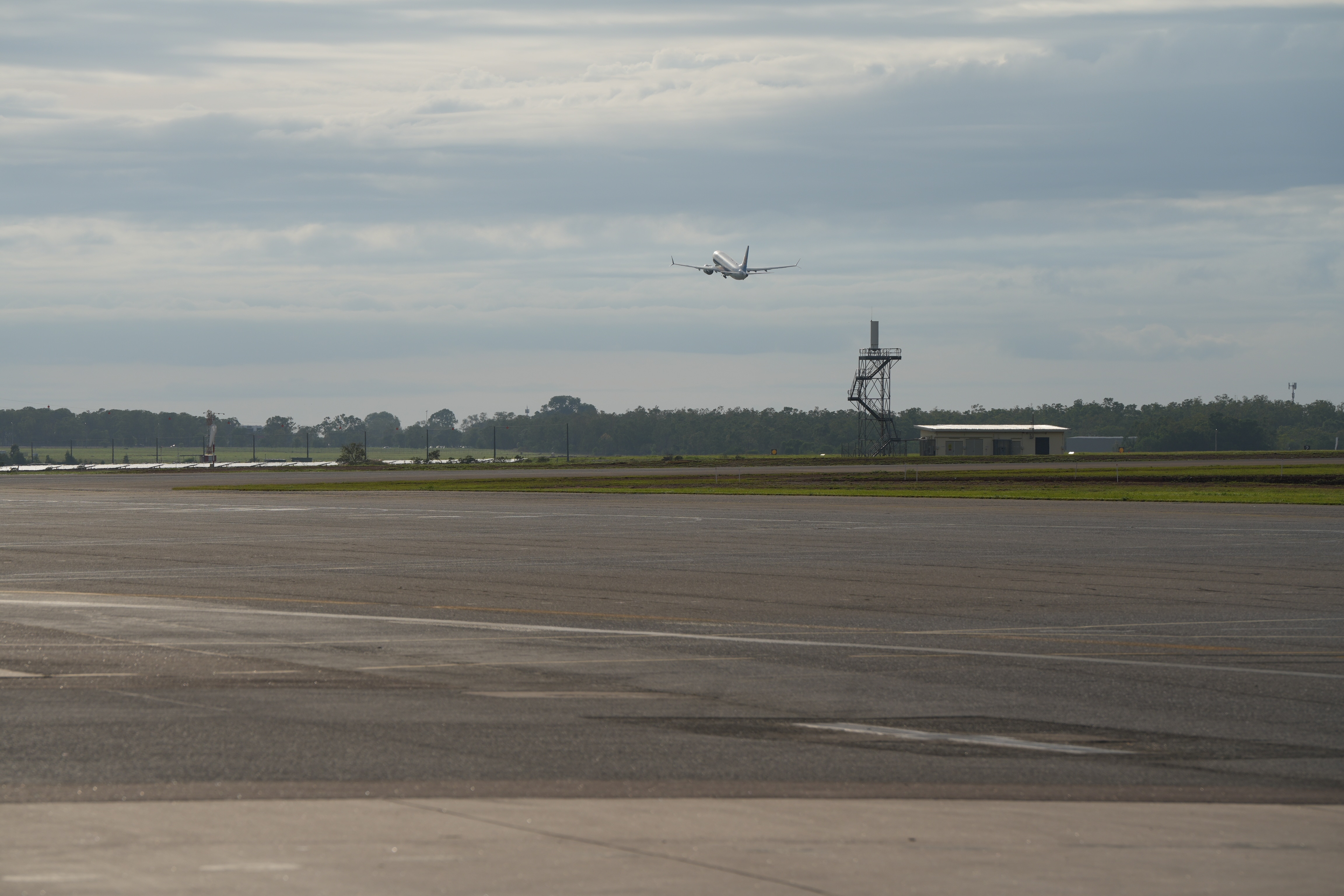 Você pode ver um avião decolando da pista de um aeroporto.