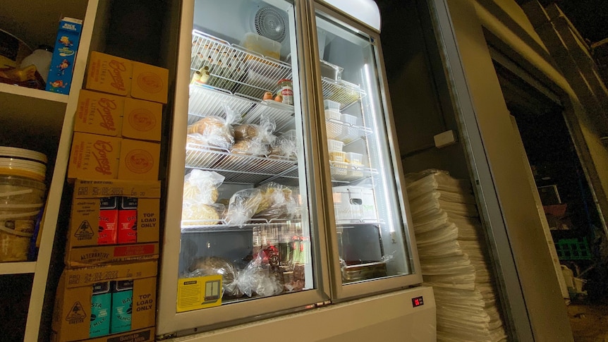 A display fridge full of food at an angle.