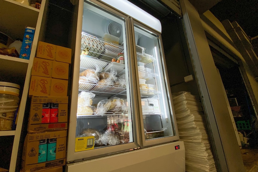 A display fridge full of food at an angle.