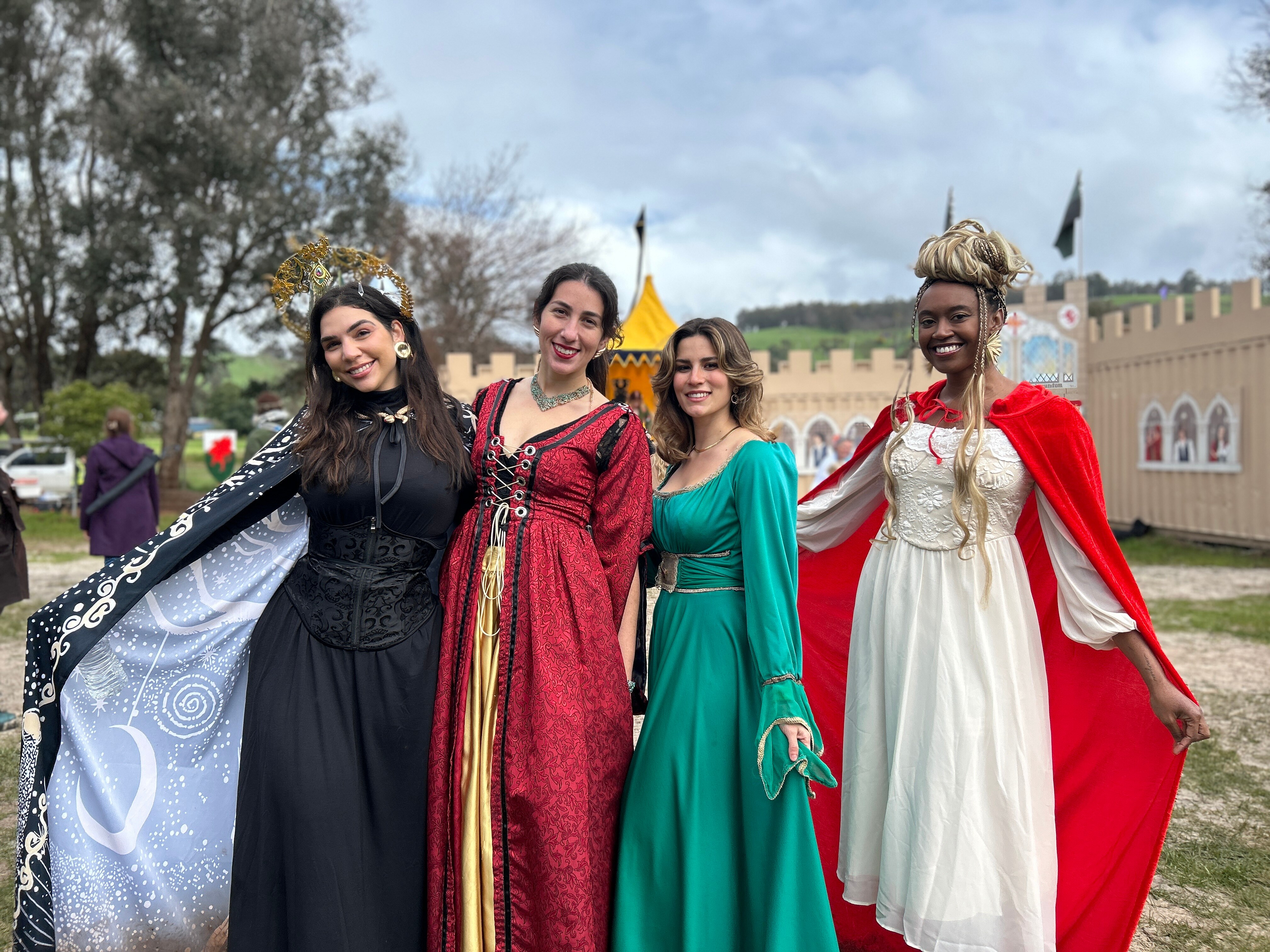 Women dressed up in long flowing medieval dresses.