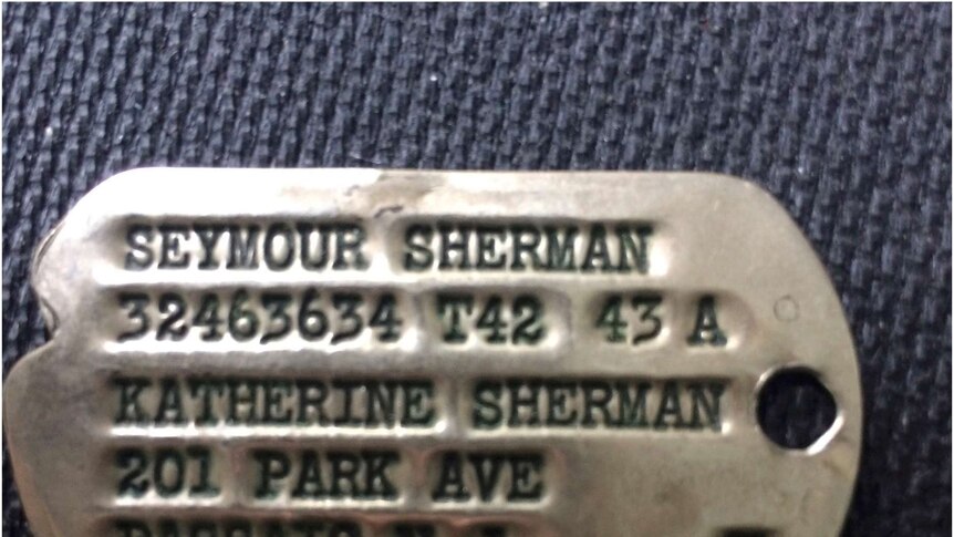 The shiny metal dog tag of Nancy Sherman's father, Seymour Sherman.