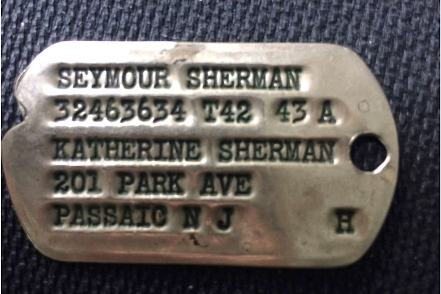 The shiny metal dog tag of Nancy Sherman's father, Seymour Sherman.