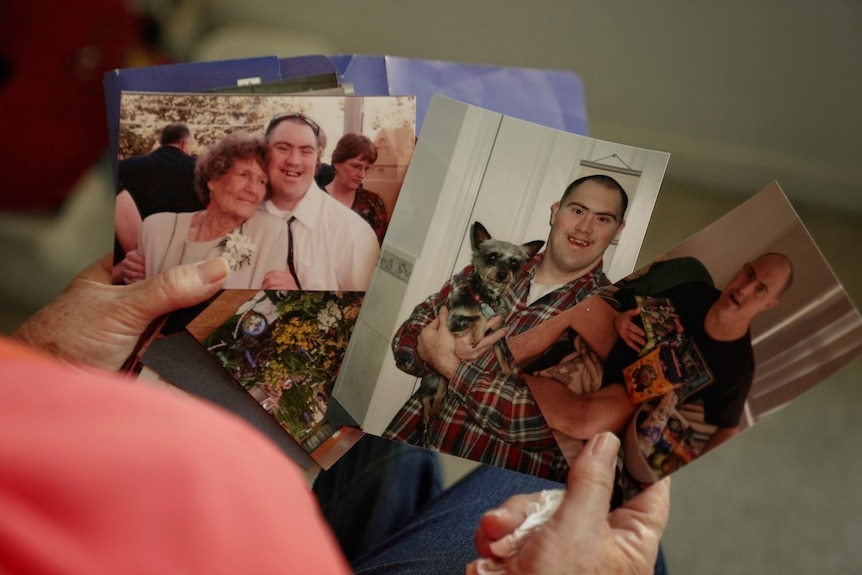 Robert Tremble holds family photos of her son Robert