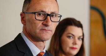 Richard Di Natale looks at the camera at a press conference.