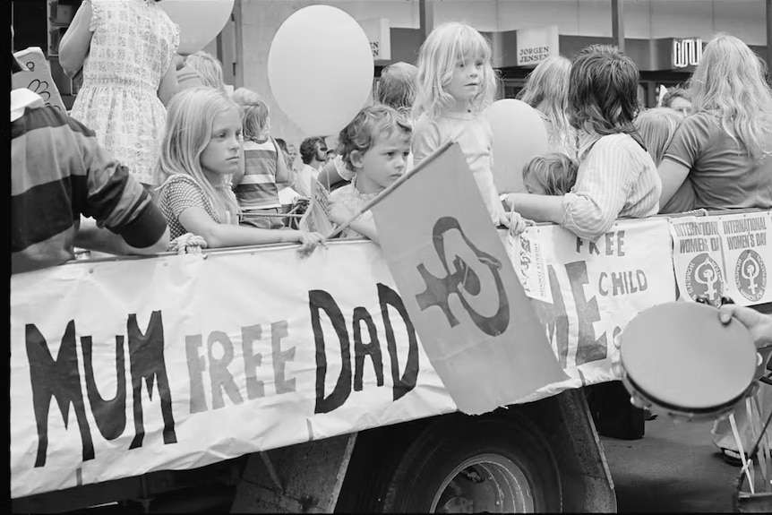 Kids behind a protest poster