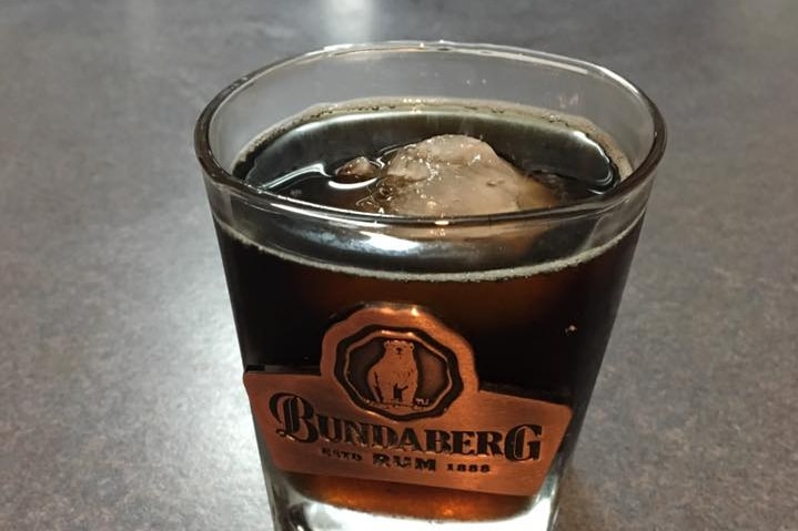 A piece of hail sits in a cup in a drink.