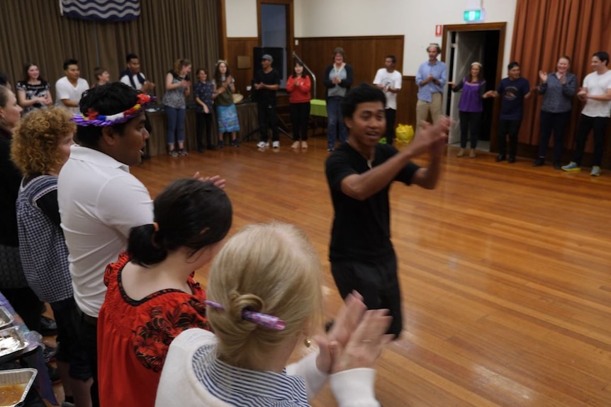 One of the Kiribati workers running around the inside of the circle formed by the crowd