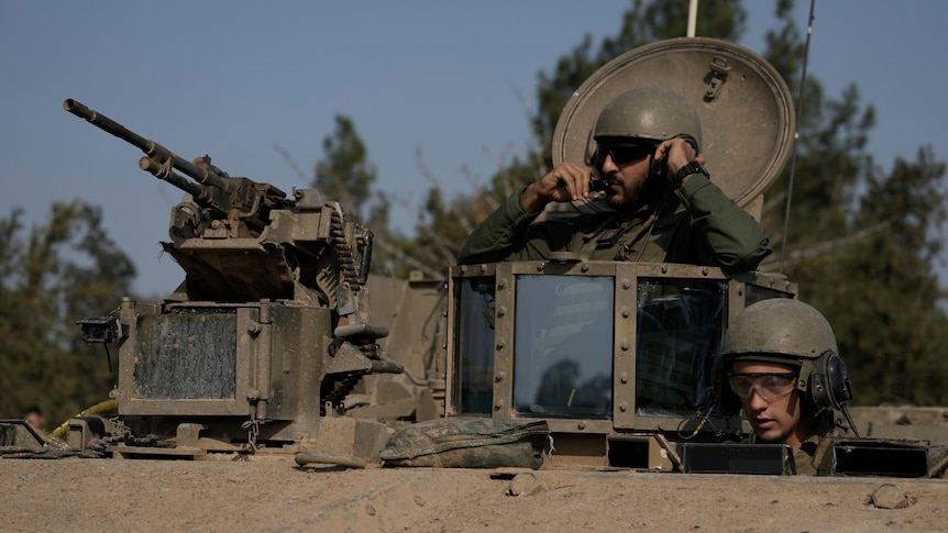 Israeli soldiers sit in an armored vehicle near the border of the Gaza Strip.
