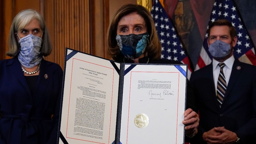 House Speaker Nancy Pelosi of Calif., displays the signed article of impeachment against President Donald Trump