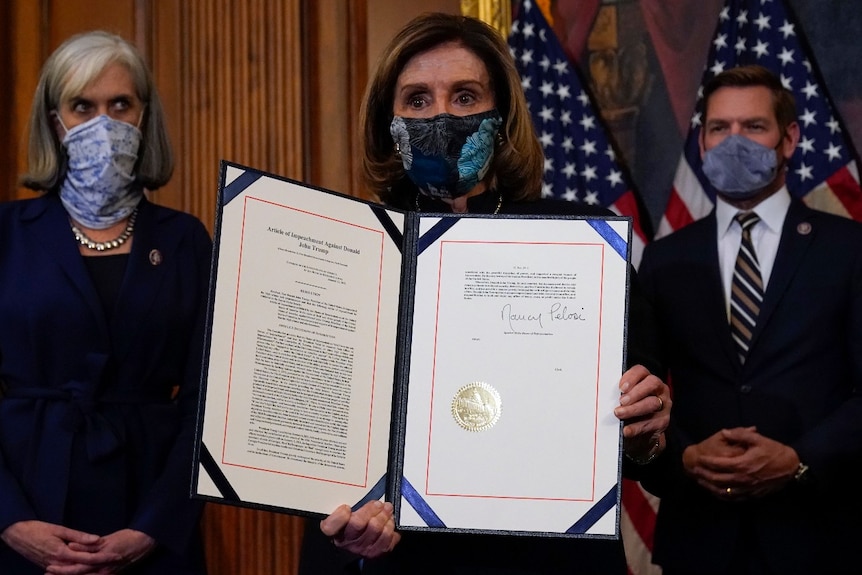 House Speaker Nancy Pelosi of Calif., displays the signed article of impeachment against President Donald Trump