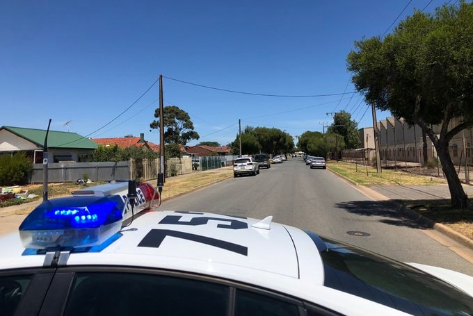 A suburban street with police cars parked.