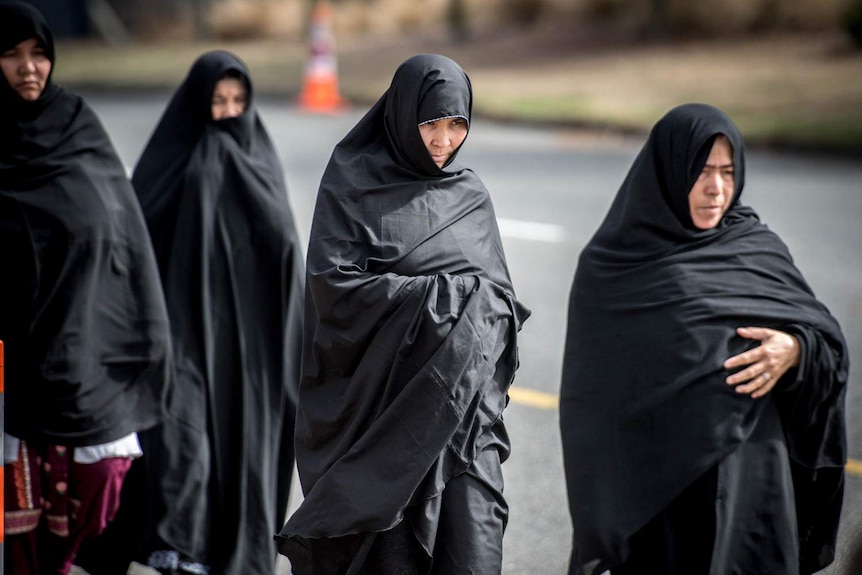 Women in hijabs walking in a line.