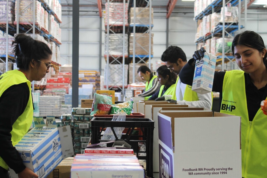 volunteers packing boxes in large warehouse