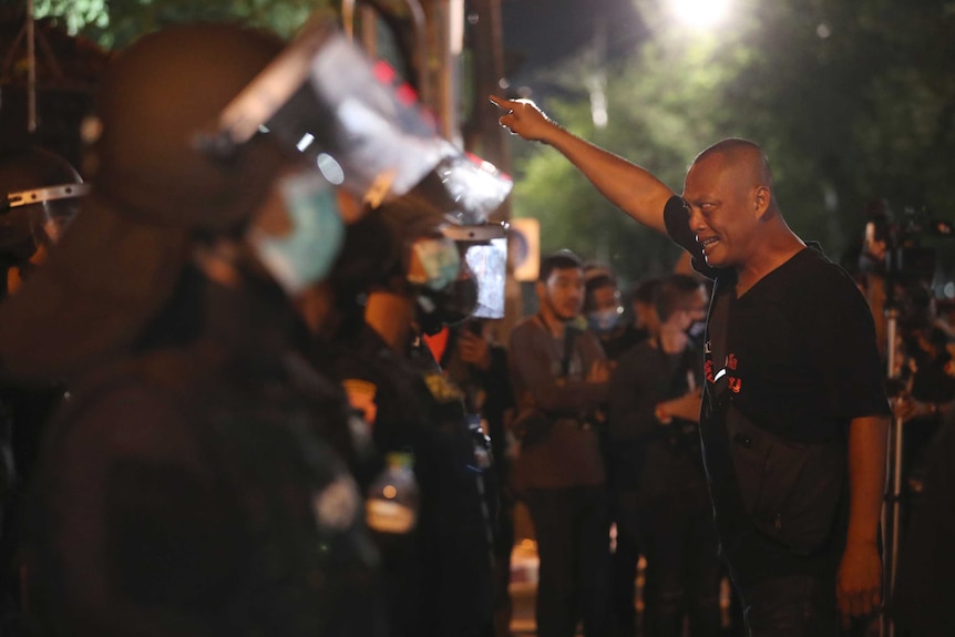 A protester in Bangkok, Thailand points and shouts in the face of police.