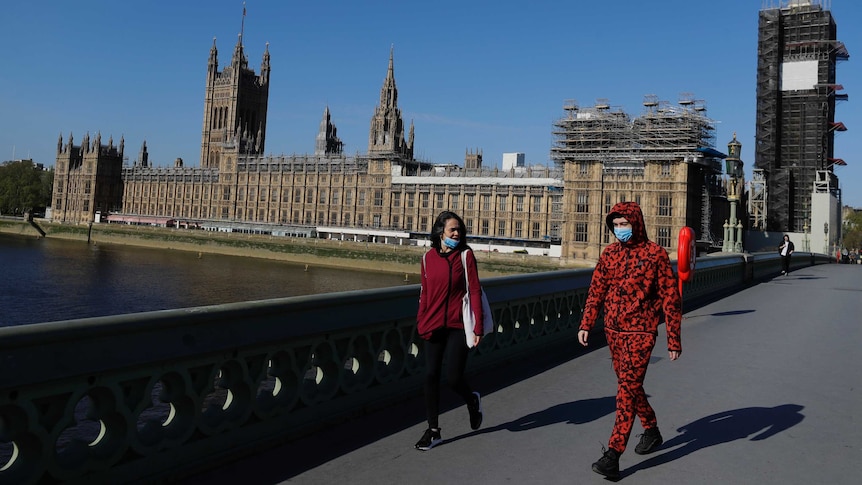 People wear masks as they walk near Britain's Houses of Parliament.