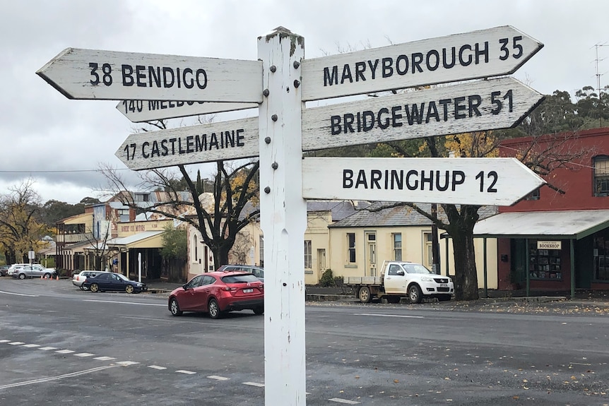 A street sign with the markings of nearest towns and their distance in kilometres.