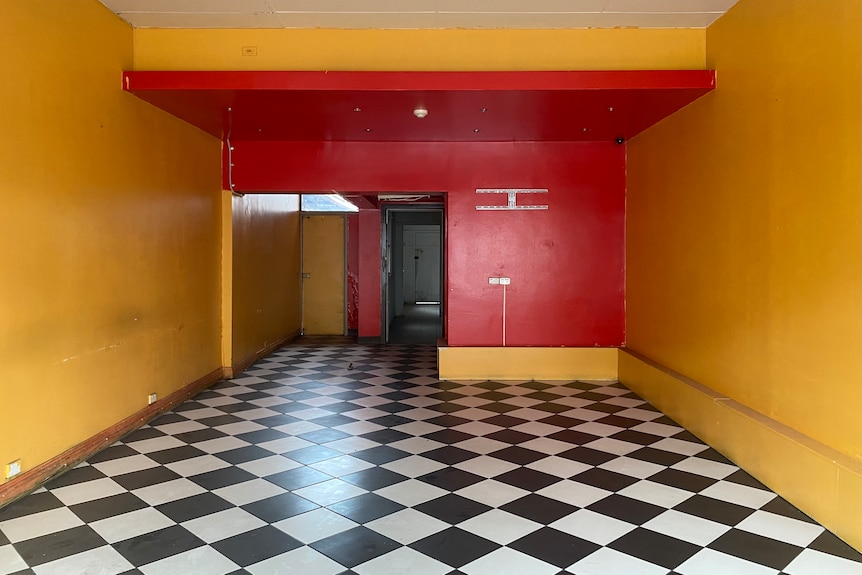 An empty shopfront with yellow painted walls.