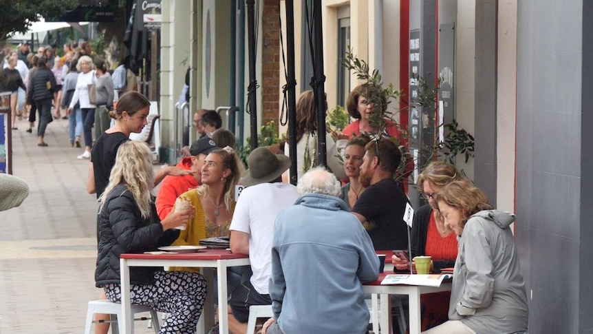Crowds of tourists eating at local cafes on the main street of Milton.