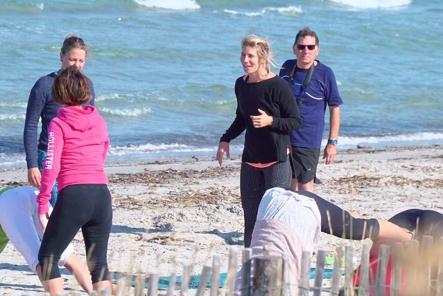 A group of people dressed in active wear are shown standing or in yoga poses