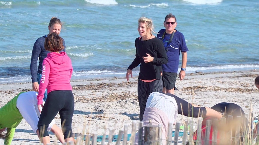 A group of people dressed in active wear are shown standing or in yoga poses