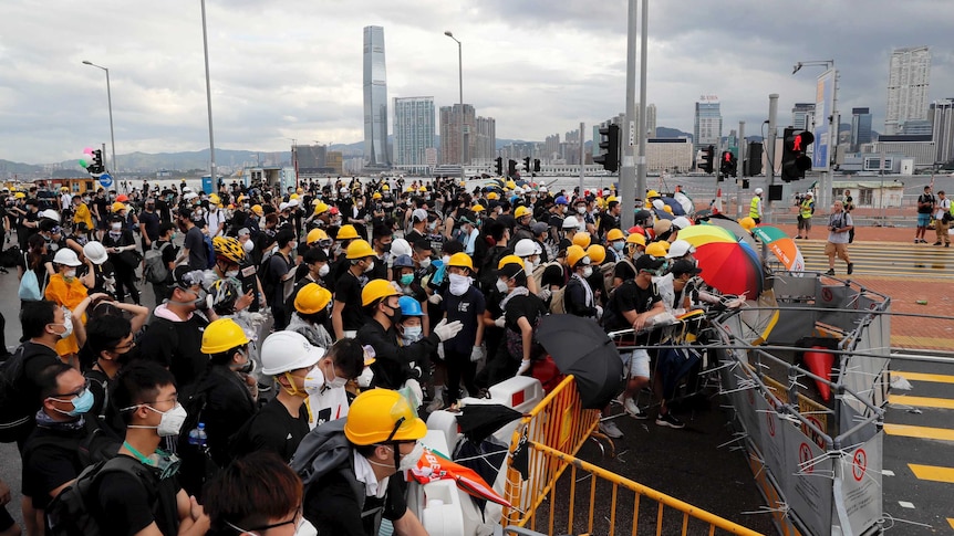 Protesters place barricades across a road in Hong Kong.