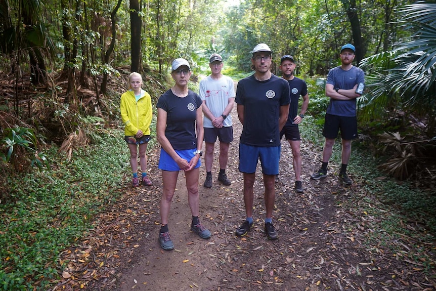 Six people standing on a running trail in the bush