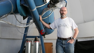 Rob McNaught is pictured with a large space telescope.
