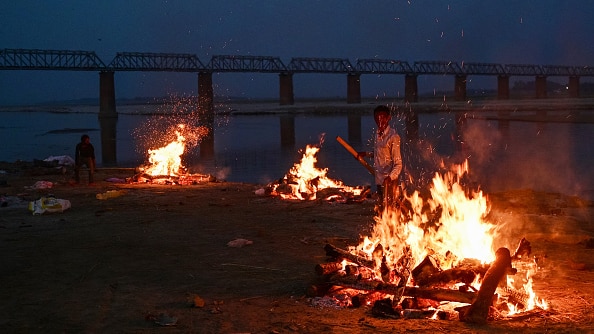 Fires cremating unclaimed bodies burn at night on the shore of the Ganges River