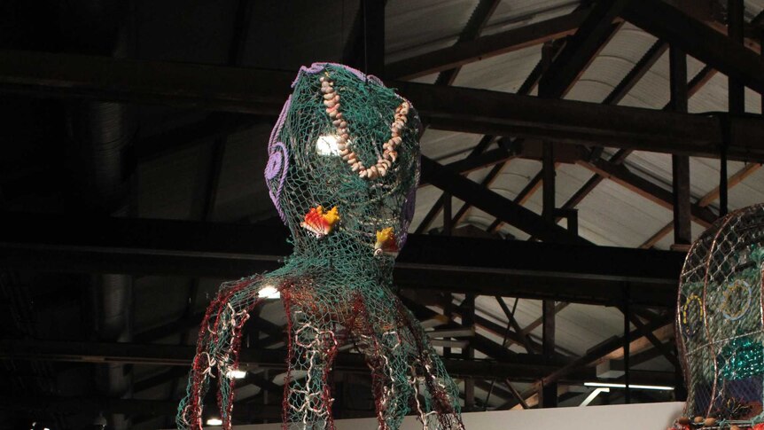 Steven Kepper looks up at his giant octopus art, created with recycled materials from the Great Barrier Reef.